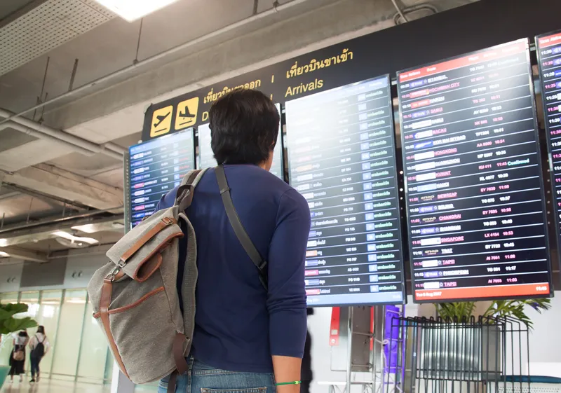 Person looking at arrivals board in an airport