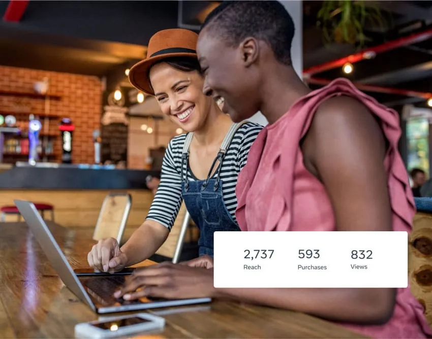 Two people in front of a laptop getting ready to run a Facebook ad campaign