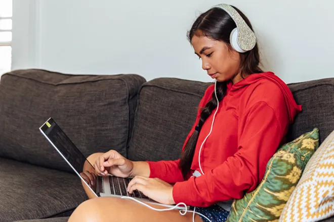 A student on her laptop watching a Meta Certification online course