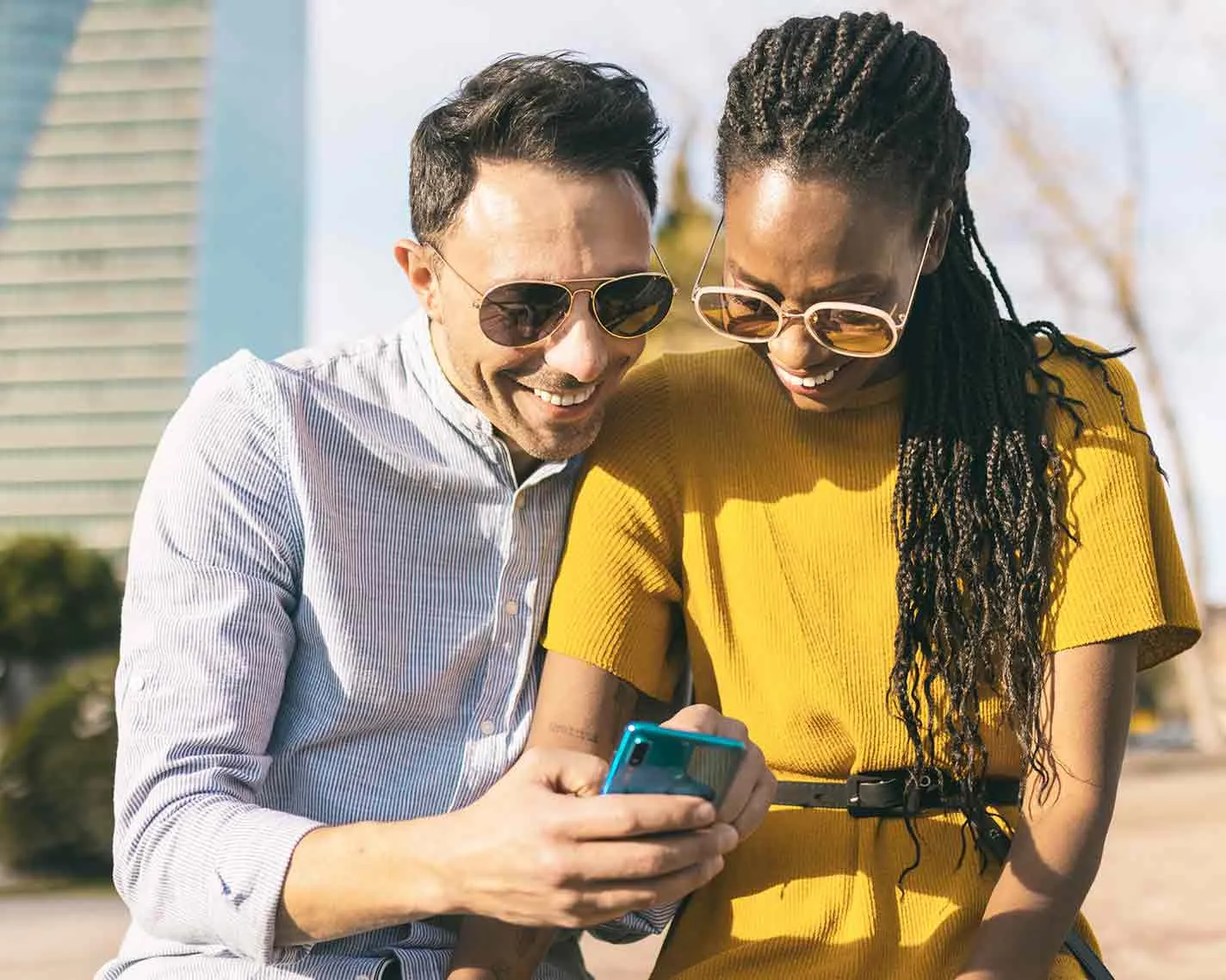 Woman putting on a virtual reality headset while two smiling friends watch her