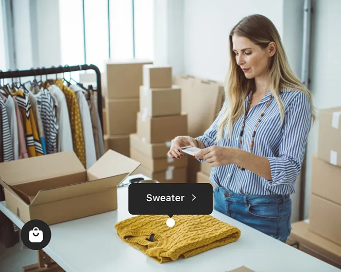 woman taking photos of merchandise with her phone – enable shopping in Facebook apps