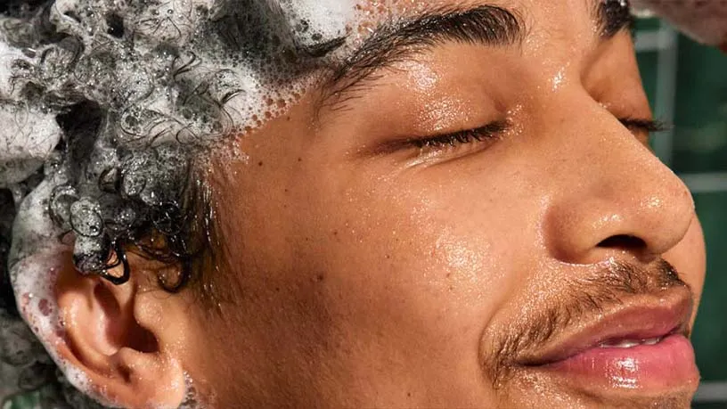Close-up shot of man with shampoo in hair looking relaxed