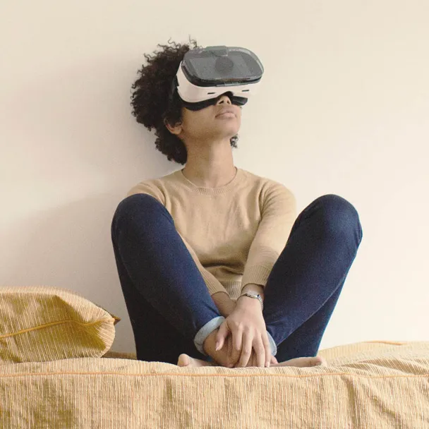 A woman wearing a virtual reality headset to enjoy an immersive entertainment experience